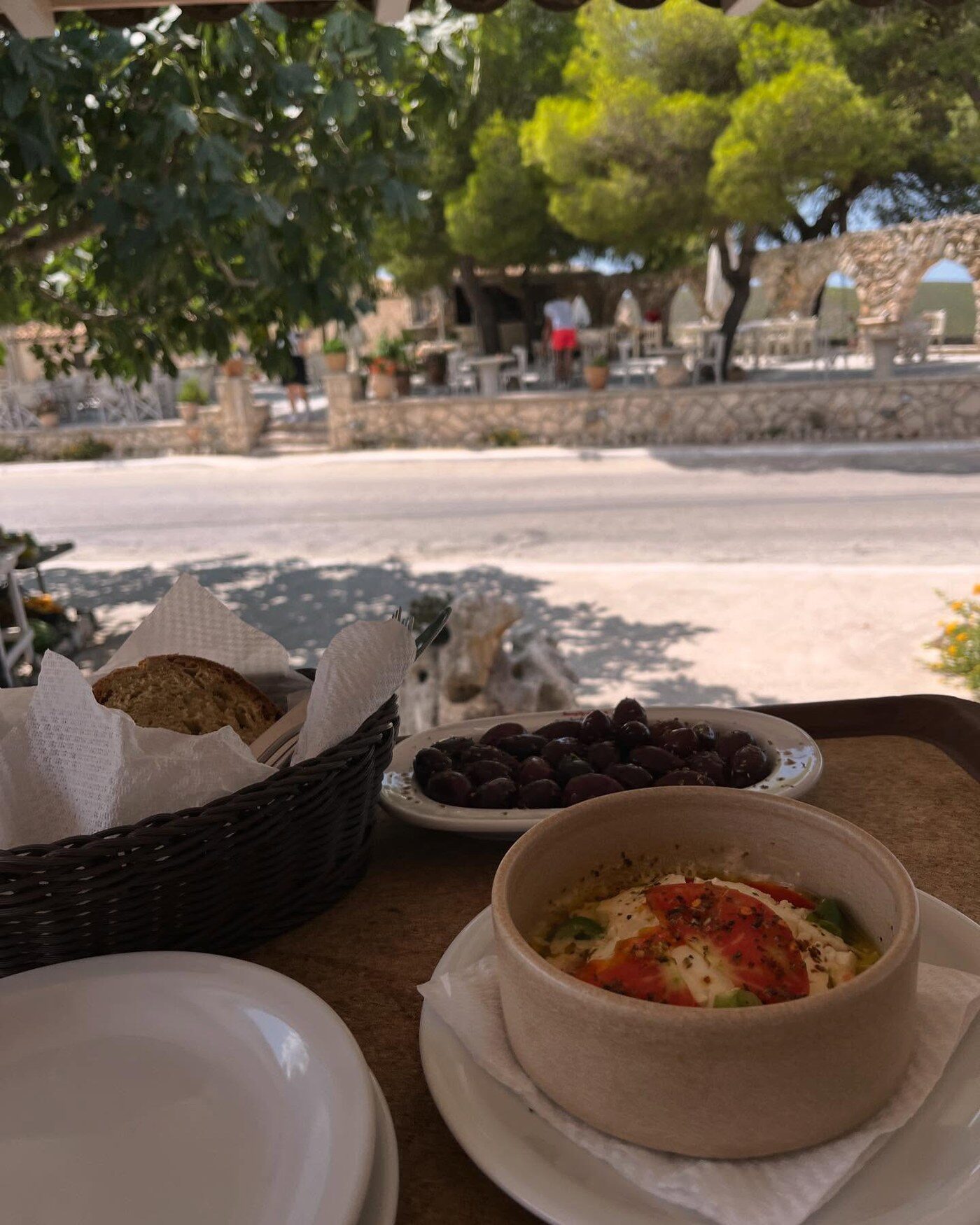 Bread, olives, and a bowl of baked feta on the terrace table